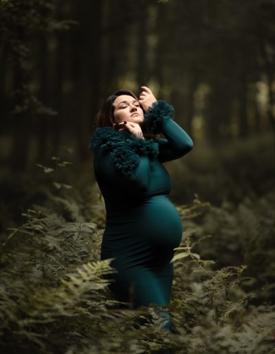Babybauchfotografie im grünen Kleid im Farn