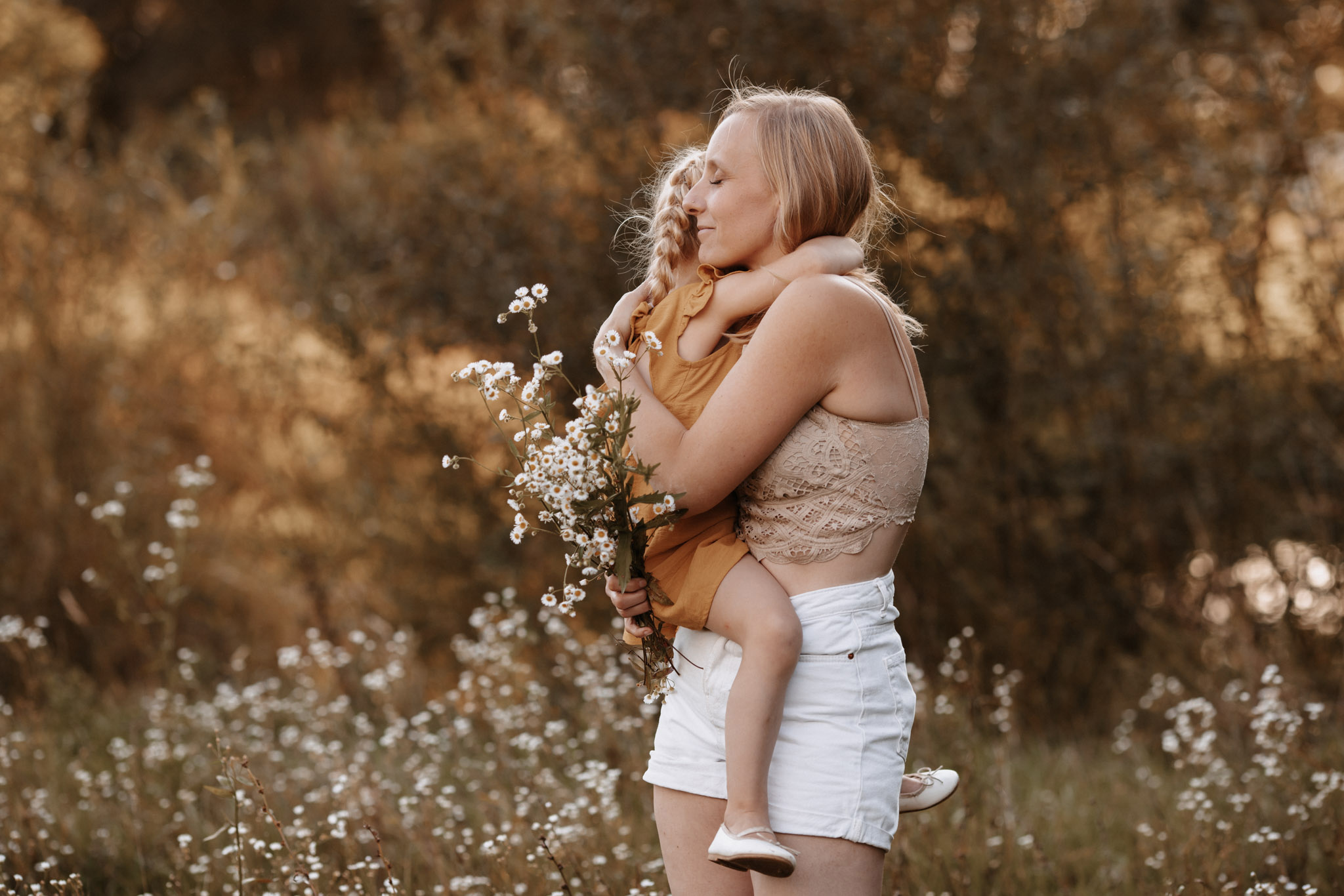 IMGL4325 Mädchen in grauem Strickmantel steht im alten hohen Gras und schaut in die Ferne. das Gesicht ist abgewand