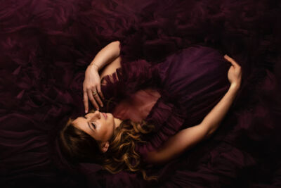 Schwangere Frau im lila Tüllkleid aus Vogelperspektive