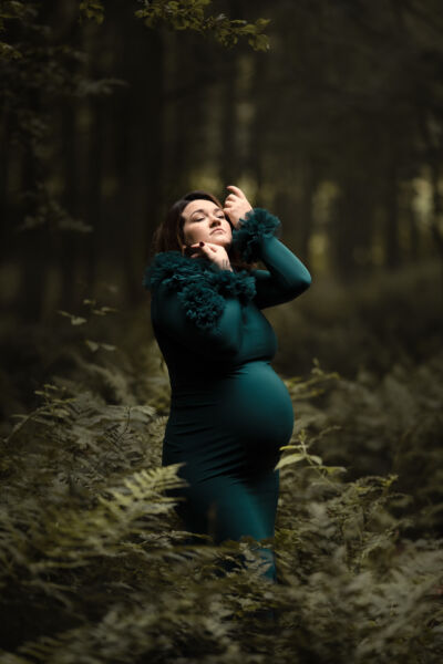 Babybauchfotografie im grünen Kleid im Farn